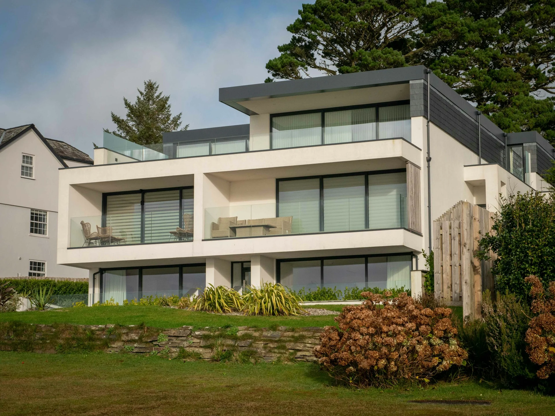 A contemporary white-rendered home with broad glazing