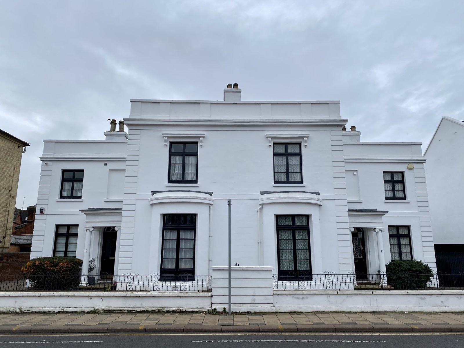 White stucco period homes with sash windows, bay windows and decorative entrance surrounds