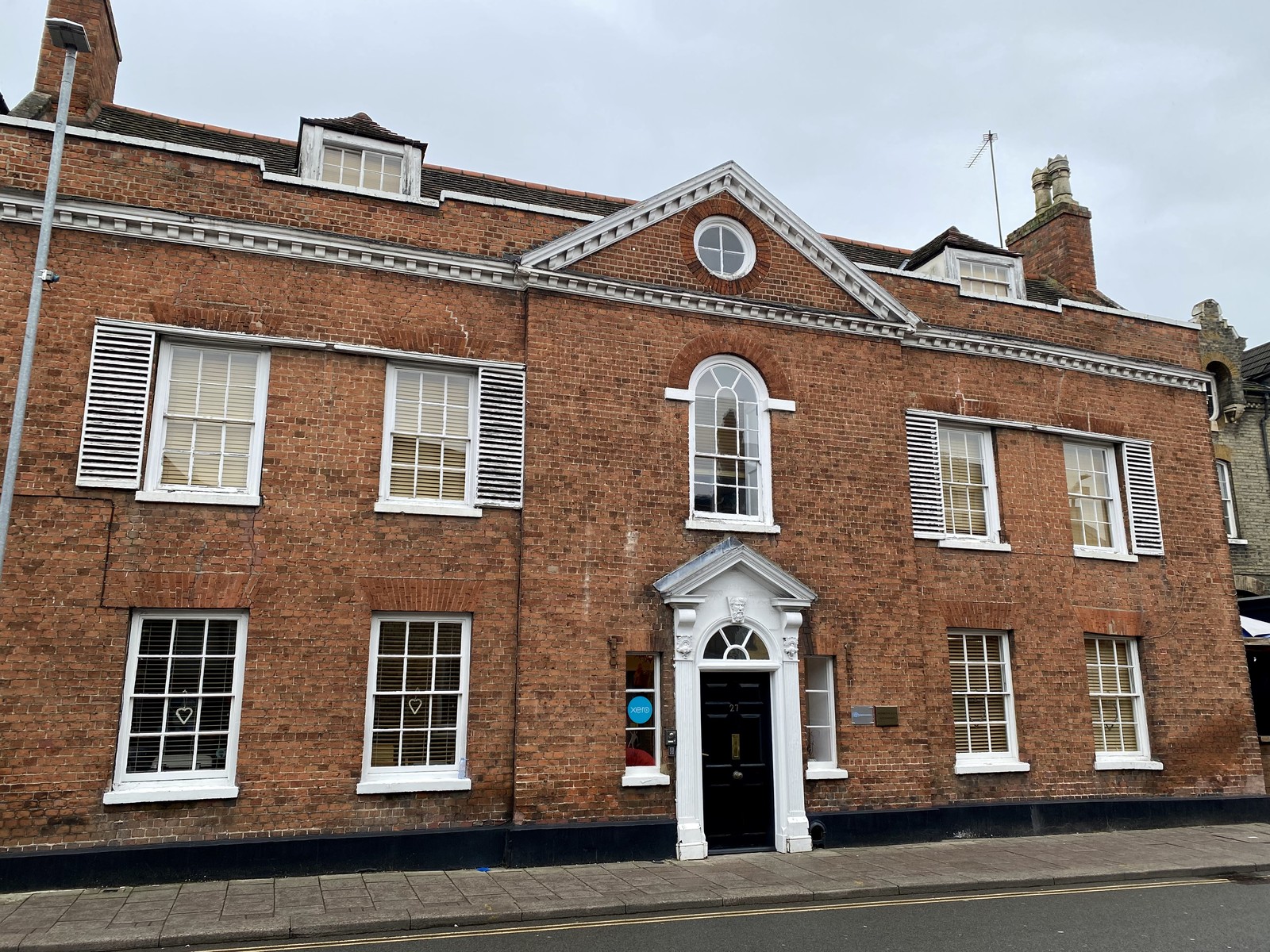 Georgian red-brick architecture with sash windows, a central pediment and arched doorway